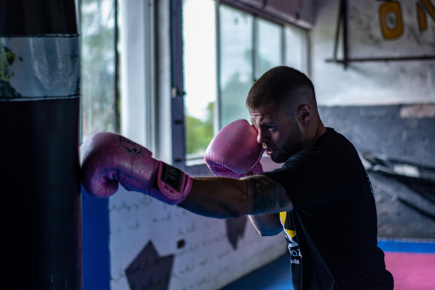 a man with boxing gloves punching a punching bag