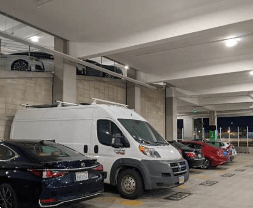 White van parked in a parking garage with other cars around