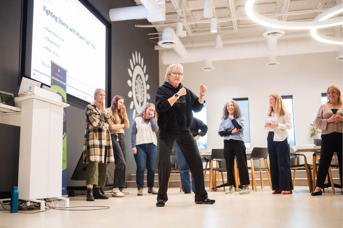 Lisa Davis demonstrating a fighting stance to corporate workshop attendees