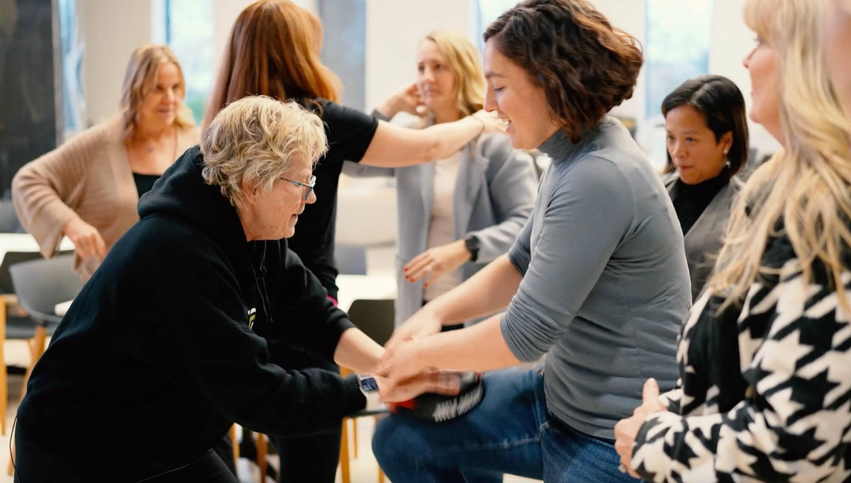 Lisa Davis teaching a student how to knee kick at a corporate event