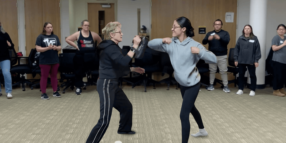 Lisa Davis instructor a group on self-defense moves with another student
