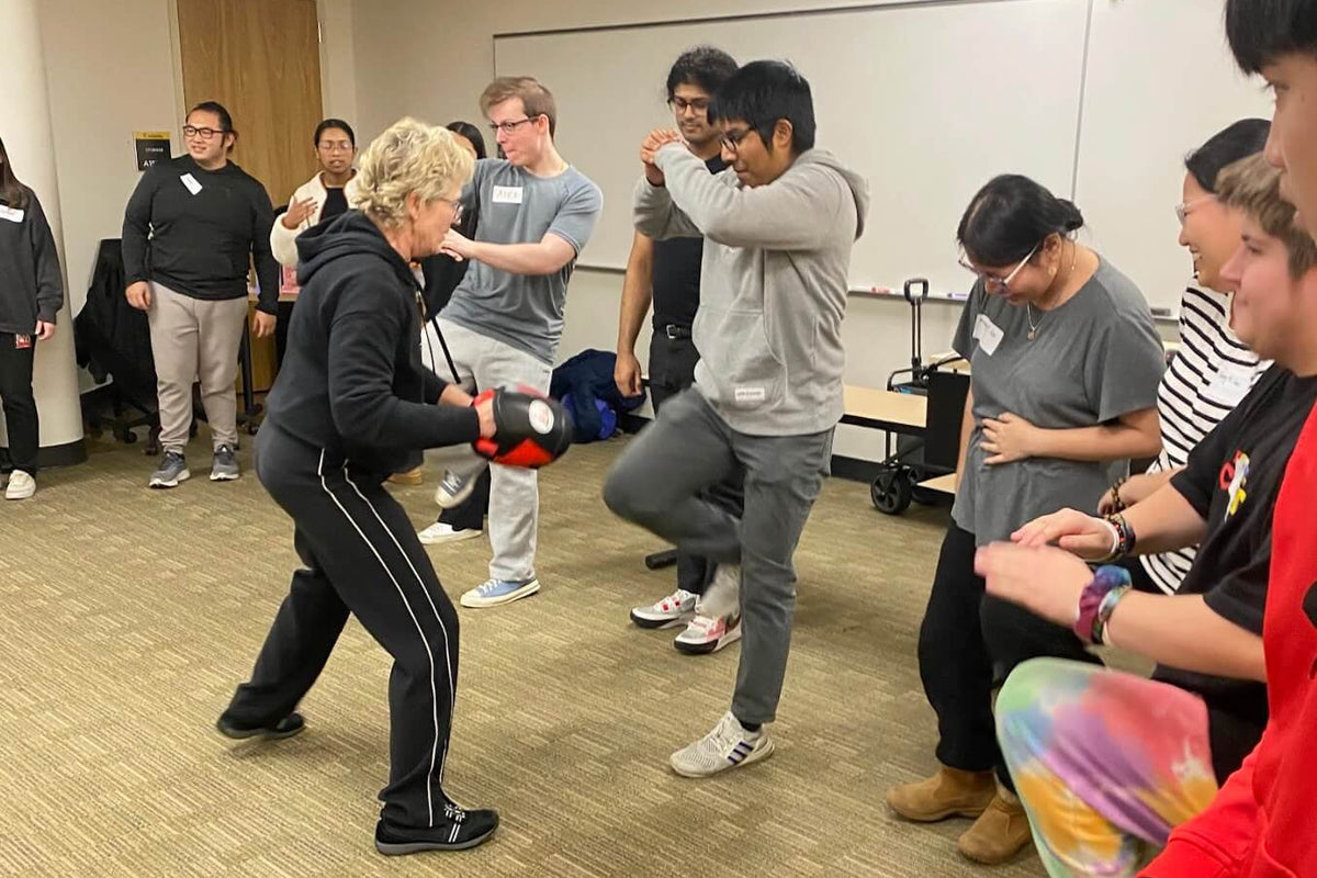 Lisa Davis coaching a college student through a knee strike