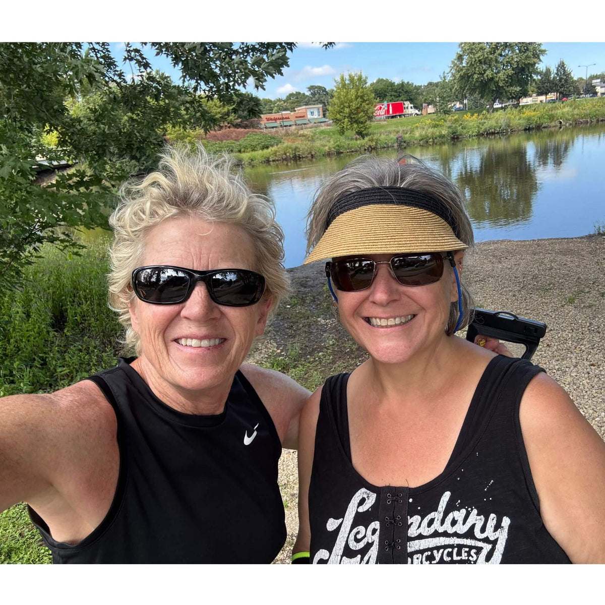 Lisa Davis posing with her sister Tina outside by a pond