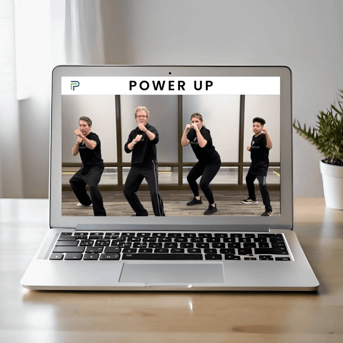 Laptop displaying four people doing the fighting stance for self-defense