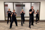 Five people practicing self-defense in a room with Lisa Davis